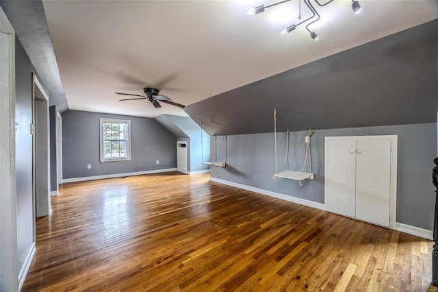 bonus room with vaulted ceiling, wood finished floors, a ceiling fan, and baseboards