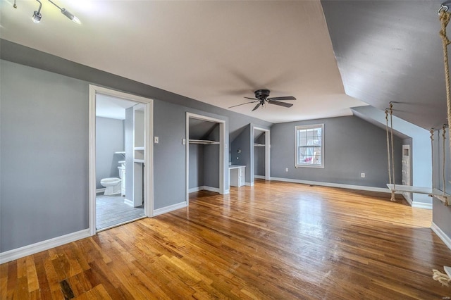 bonus room featuring a ceiling fan, wood finished floors, baseboards, and vaulted ceiling