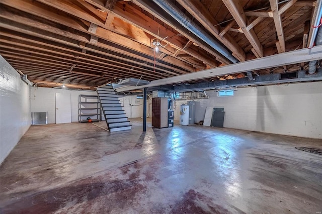 unfinished basement featuring electric water heater, stairs, and heating unit