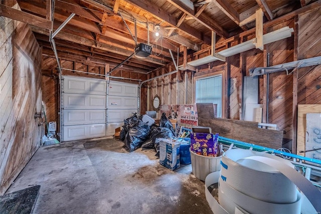 garage with wood walls and a garage door opener