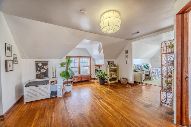 additional living space featuring wood-type flooring, lofted ceiling, and baseboards