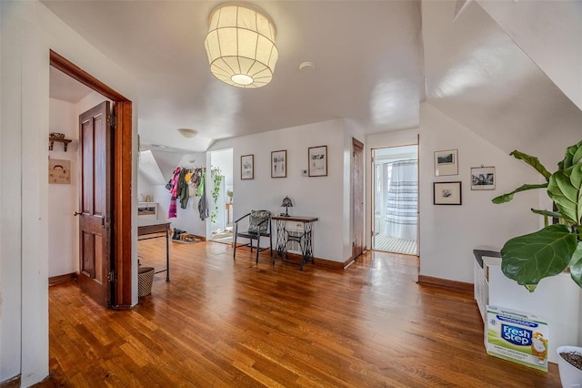 bonus room with wood finished floors, baseboards, and vaulted ceiling