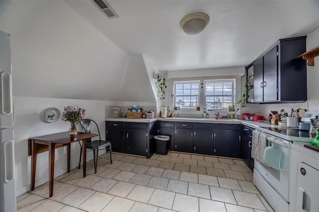 kitchen with electric stove, a sink, light tile patterned flooring, light countertops, and lofted ceiling