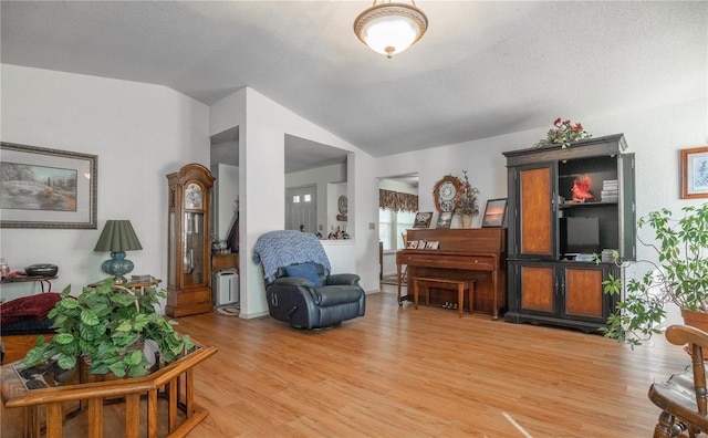 living room with lofted ceiling and light wood-style flooring