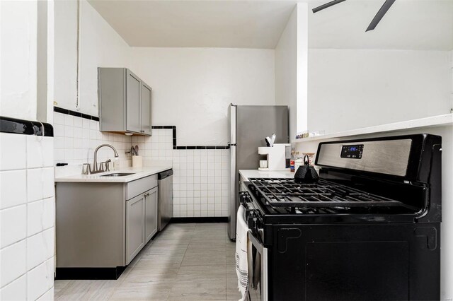 4271 Botanical Ave, Saint Louis, MO 63110 - kitchen featuring stainless steel appliances, gray cabinets, a sink, tile walls, and light countertops