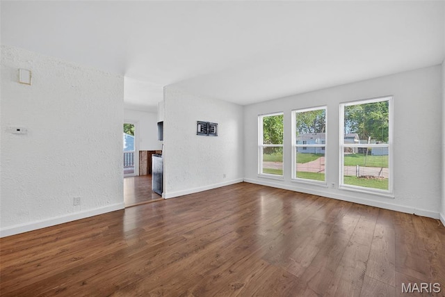 104 Wild Winds Dr, Ofallon, MO 63368 - unfurnished living room featuring plenty of natural light, wood finished floors, and a textured wall
