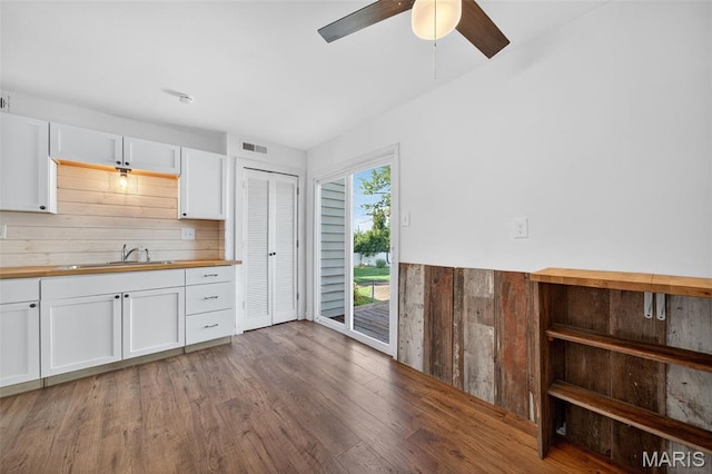 104 Wild Winds Dr, Ofallon, MO 63368 - kitchen featuring wooden counters, white cabinets, a ceiling fan, wood finished floors, and wood walls