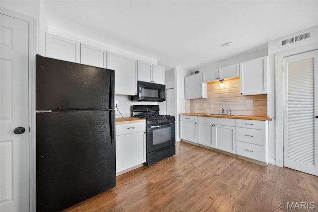 104 Wild Winds Dr, Ofallon, MO 63368 - kitchen with black appliances, butcher block countertops, light wood-type flooring, and white cabinets