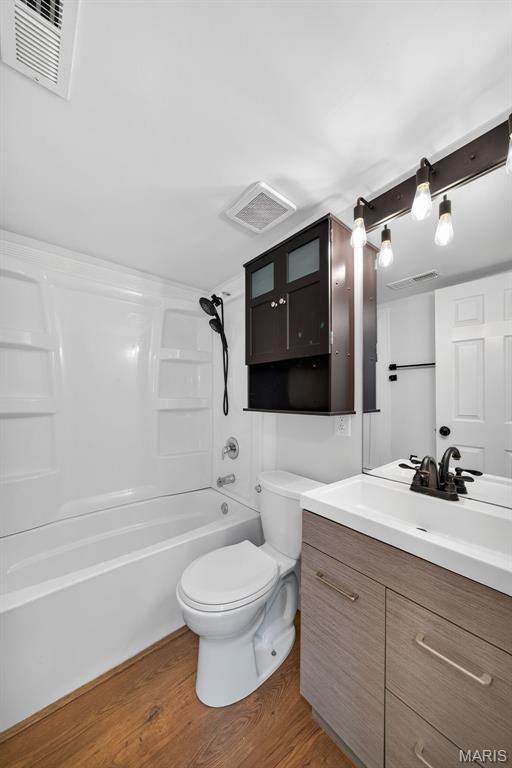 104 Wild Winds Dr, Ofallon, MO 63368 - bathroom with vanity, wood finished floors, and shower / bath combination