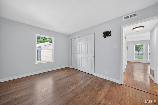 104 Wild Winds Dr, Ofallon, MO 63368 - unfurnished bedroom with hardwood / wood-style flooring, multiple windows, and a closet