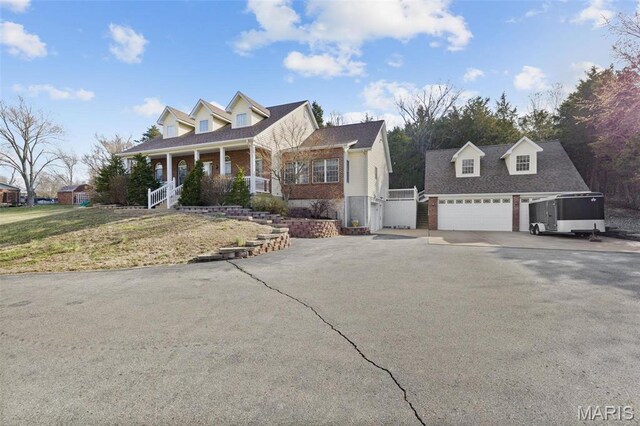 1736 Debra Ln, Arnold, MO 63010 - cape cod home featuring asphalt driveway, a porch, an outbuilding, and brick siding