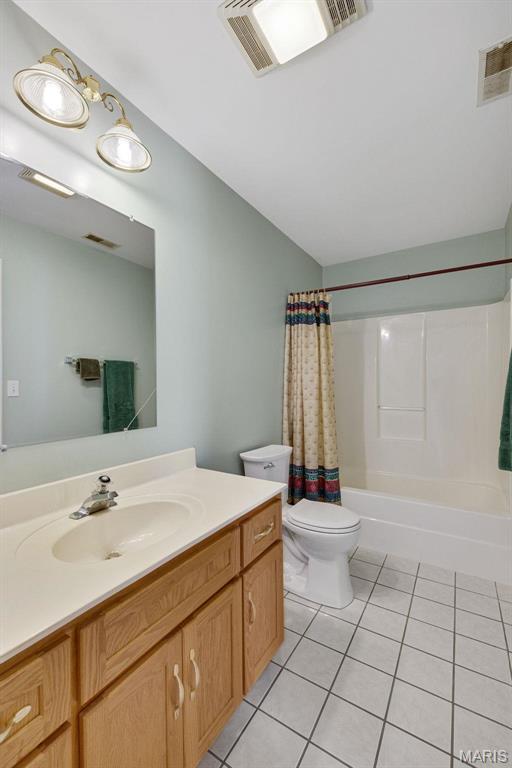 1736 Debra Ln, Arnold, MO 63010 - bathroom featuring tile patterned floors, vanity, toilet, shower / tub combo, and vaulted ceiling