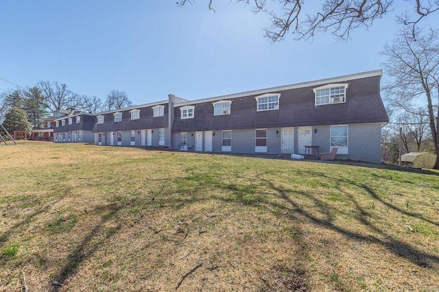 rear view of property featuring a lawn