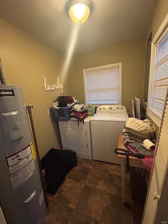 laundry area featuring water heater, separate washer and dryer, and stone finish flooring