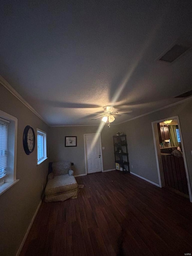 unfurnished room featuring wood finished floors, baseboards, crown molding, and a ceiling fan