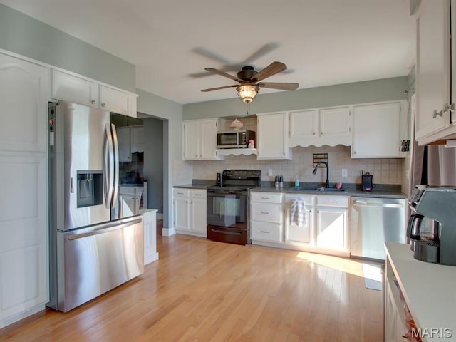 14160 Turkey Run Ct, New London, MO 63459 - kitchen featuring stainless steel appliances, a sink, decorative backsplash, a ceiling fan, and white cabinetry