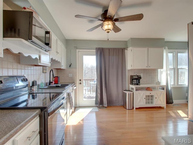14160 Turkey Run Ct, New London, MO 63459 - kitchen featuring stainless steel range with electric cooktop, a sink, light wood-style floors, ceiling fan, and white cabinetry