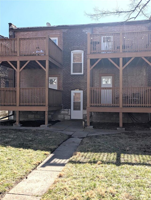 2039 Maury Ave, Saint Louis, MO 63110 - rear view of property featuring a balcony, a yard, and brick siding