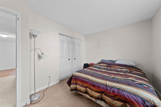 bedroom featuring carpet, a textured ceiling, a closet, and baseboards