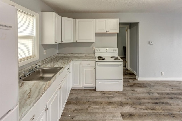 1125 N Market St, Sparta, IL 62286 - kitchen with white appliances, a sink, white cabinetry, and light wood-style floors