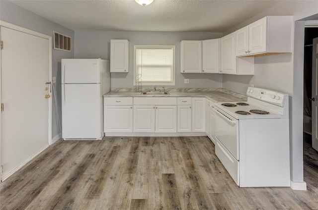 1125 N Market St, Sparta, IL 62286 - kitchen with white appliances, a sink, white cabinetry, light wood-style flooring, and a textured ceiling