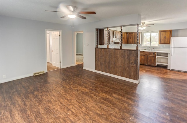 1125 N Market St, Sparta, IL 62286 - kitchen featuring freestanding refrigerator, a ceiling fan, dark wood-style floors, brown cabinetry, and a sink