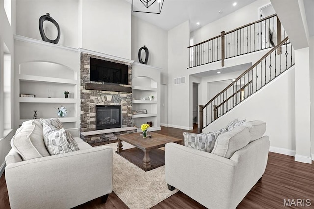 1 Canebrake Ct, Wentzville, MO 63385 - living room with a stone fireplace, baseboards, a high ceiling, stairs, and dark wood-style flooring