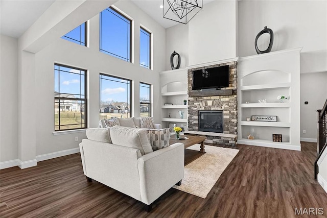 1 Canebrake Ct, Wentzville, MO 63385 - living area with baseboards, a stone fireplace, dark wood finished floors, built in shelves, and a towering ceiling