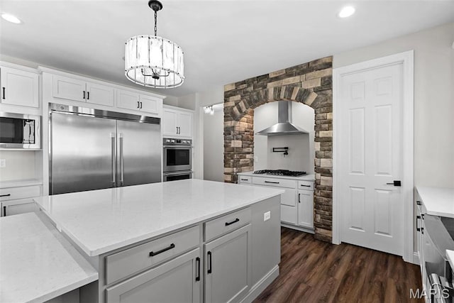 1 Canebrake Ct, Wentzville, MO 63385 - kitchen with built in appliances, wall chimney exhaust hood, dark wood-style floors, recessed lighting, and a chandelier