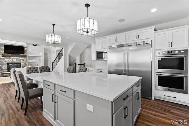 1 Canebrake Ct, Wentzville, MO 63385 - kitchen featuring built in appliances, a chandelier, open floor plan, gray cabinets, and dark wood-style floors