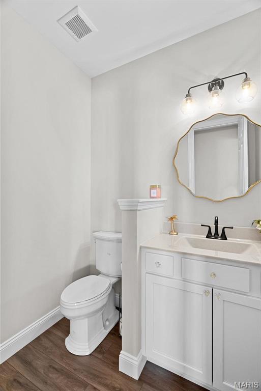 1 Canebrake Ct, Wentzville, MO 63385 - bathroom featuring toilet, wood finished floors, baseboards, and vanity