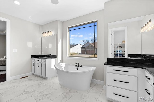 1 Canebrake Ct, Wentzville, MO 63385 - ensuite bathroom with marble look tiles, two vanities, baseboards, and a soaking tub