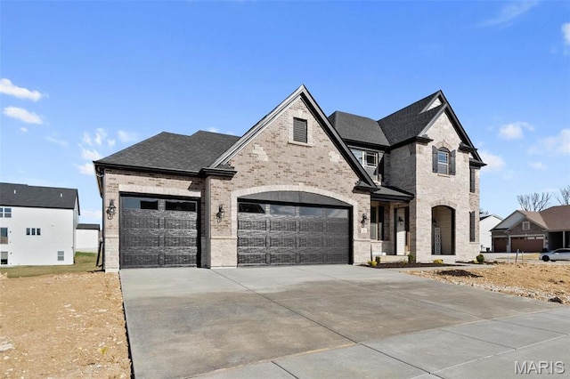 1 Canebrake Ct, Wentzville, MO 63385 - french country home with concrete driveway, brick siding, a garage, and roof with shingles
