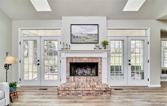 269 Bennington Dr, Troy, MO 63379 - living area featuring french doors, a skylight, wood finished floors, and a fireplace