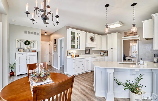 269 Bennington Dr, Troy, MO 63379 - kitchen with white cabinets, light wood-style floors, a peninsula, and light countertops