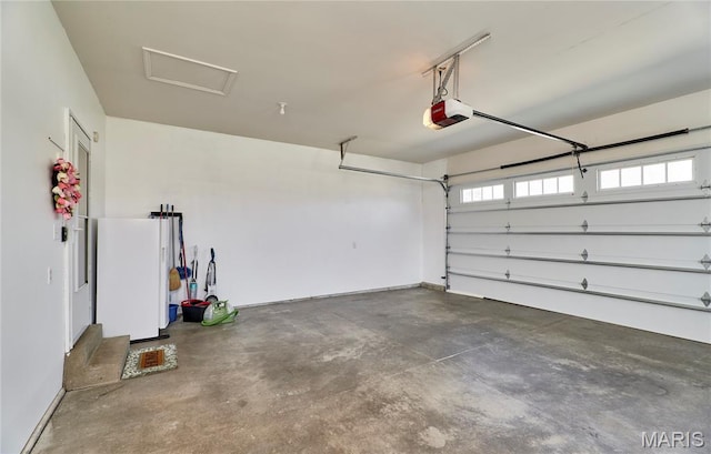 269 Bennington Dr, Troy, MO 63379 - garage with a garage door opener and freestanding refrigerator