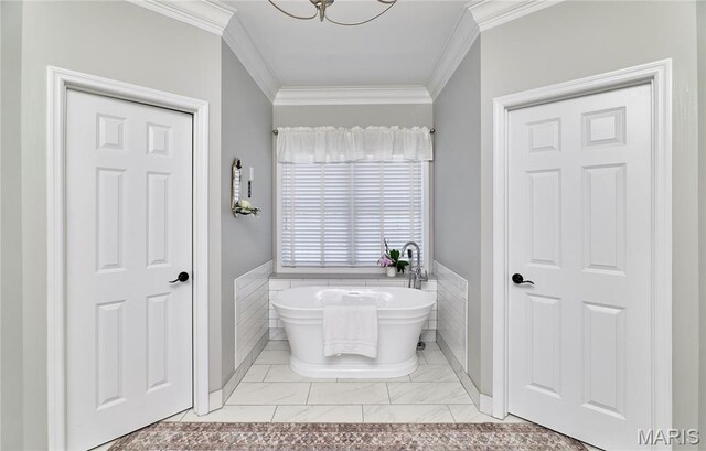 269 Bennington Dr, Troy, MO 63379 - bathroom featuring ornamental molding, a freestanding tub, tile walls, marble look tile flooring, and a wainscoted wall