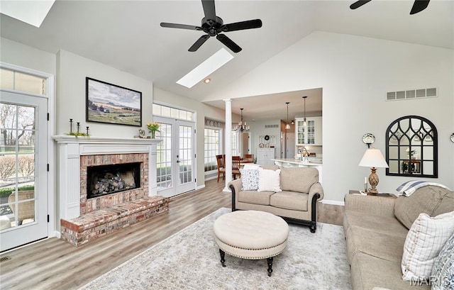 269 Bennington Dr, Troy, MO 63379 - living room with ceiling fan, high vaulted ceiling, wood finished floors, a skylight, and a fireplace