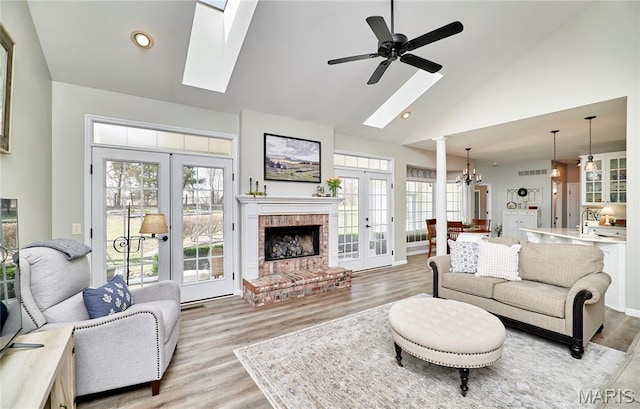 269 Bennington Dr, Troy, MO 63379 - living room featuring high vaulted ceiling, french doors, a chandelier, light wood-style flooring, and a ceiling fan