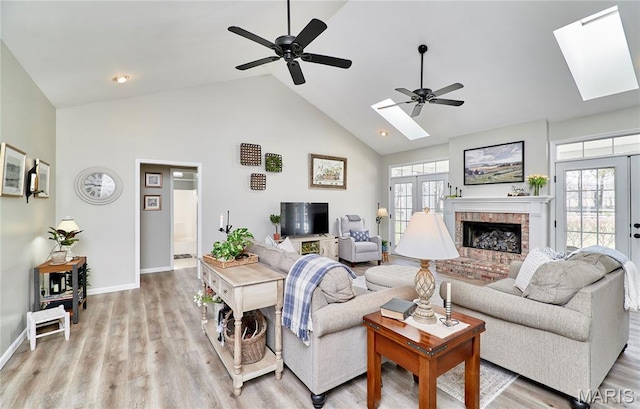 269 Bennington Dr, Troy, MO 63379 - living area featuring a skylight, high vaulted ceiling, a ceiling fan, light wood-style flooring, and a fireplace