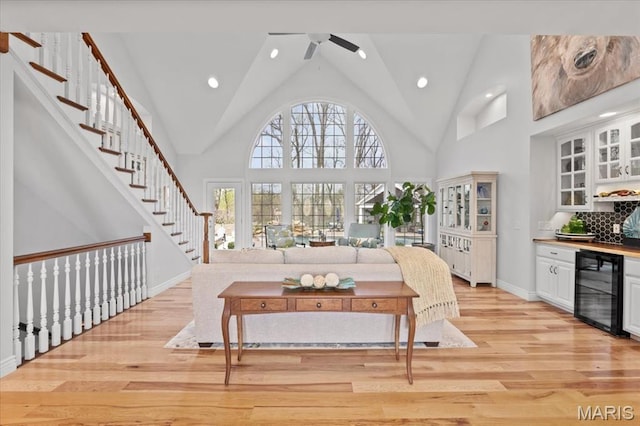 261 US Dr, Wentzville, MO 63385 - living room with wine cooler, a ceiling fan, light wood finished floors, high vaulted ceiling, and a dry bar