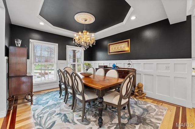 261 US Dr, Wentzville, MO 63385 - dining room with a chandelier, a raised ceiling, wainscoting, recessed lighting, and light wood-type flooring