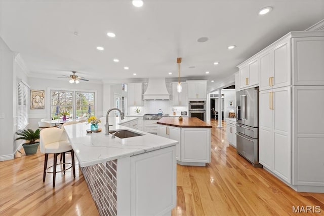 261 US Dr, Wentzville, MO 63385 - kitchen with a sink, appliances with stainless steel finishes, a large island with sink, custom exhaust hood, and a ceiling fan