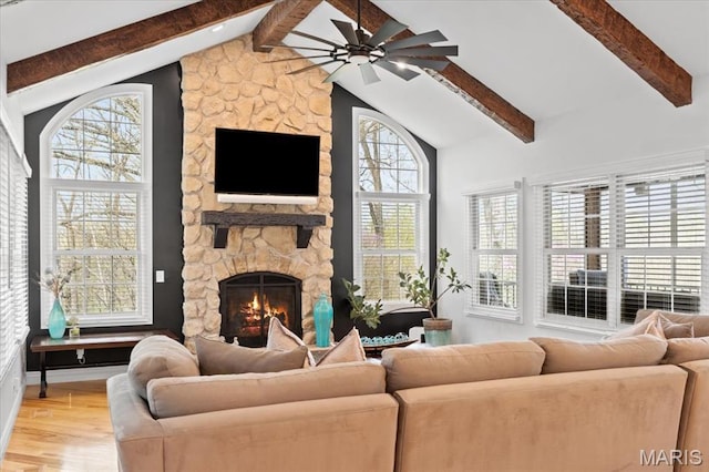 261 US Dr, Wentzville, MO 63385 - living room featuring beam ceiling, ceiling fan, light wood-style floors, a stone fireplace, and high vaulted ceiling