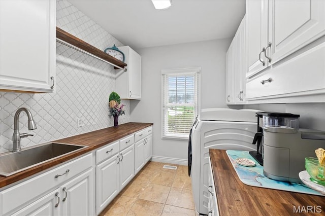261 US Dr, Wentzville, MO 63385 - washroom featuring cabinet space, washing machine and clothes dryer, baseboards, and light tile patterned floors