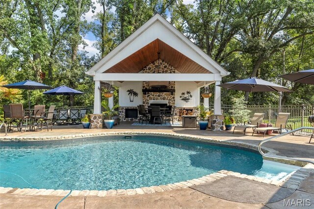 261 US Dr, Wentzville, MO 63385 - view of pool featuring fence, a patio area, a storage structure, an outdoor stone fireplace, and a gazebo