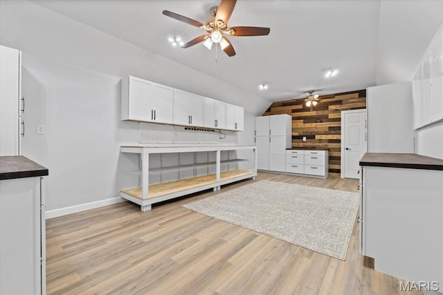 261 US Dr, Wentzville, MO 63385 - unfurnished living room with a ceiling fan, vaulted ceiling, wood walls, light wood-type flooring, and baseboards