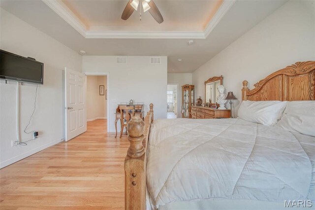 17205 Elk Prairie Dr, Rolla, MO 65401 - bedroom with a tray ceiling, light wood-style floors, ornamental molding, ceiling fan, and baseboards