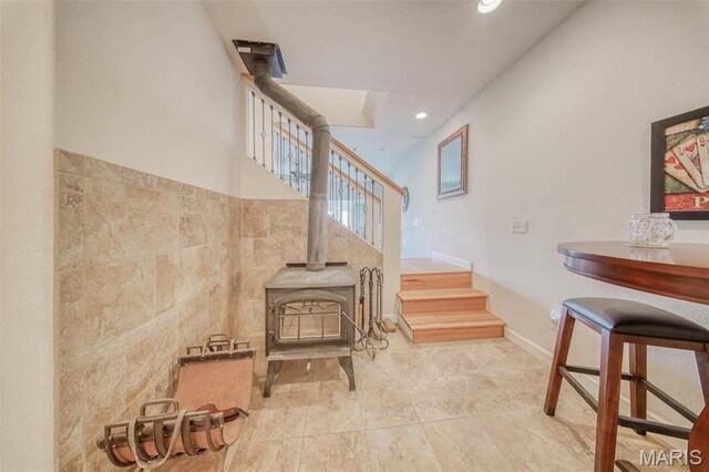 17205 Elk Prairie Dr, Rolla, MO 65401 - stairs with a wood stove, recessed lighting, tile walls, and baseboards