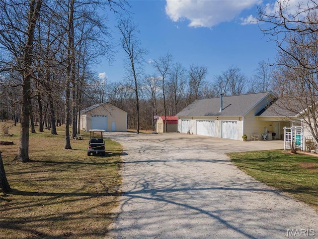 17205 Elk Prairie Dr, Rolla, MO 65401 - view of front of property with asphalt driveway, an outdoor structure, a detached garage, and a front yard